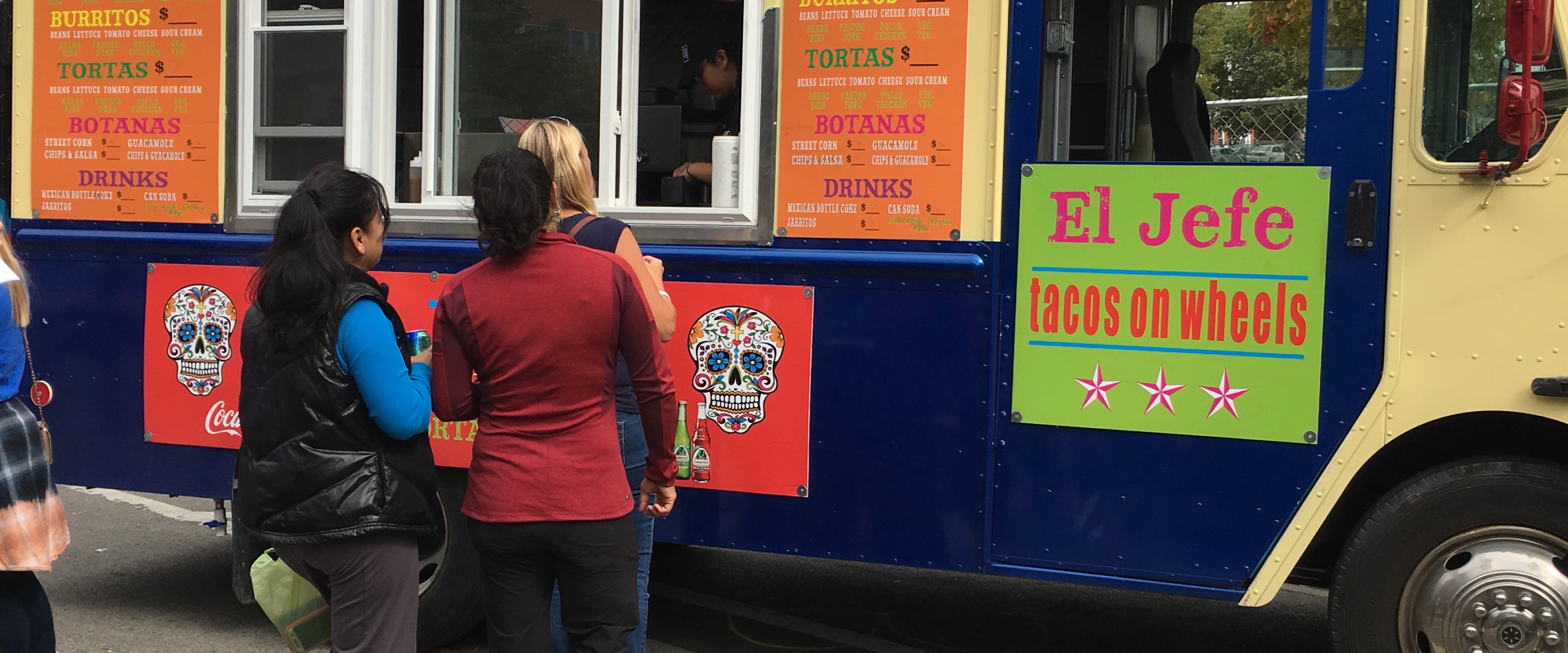 people standing in line at a food truck